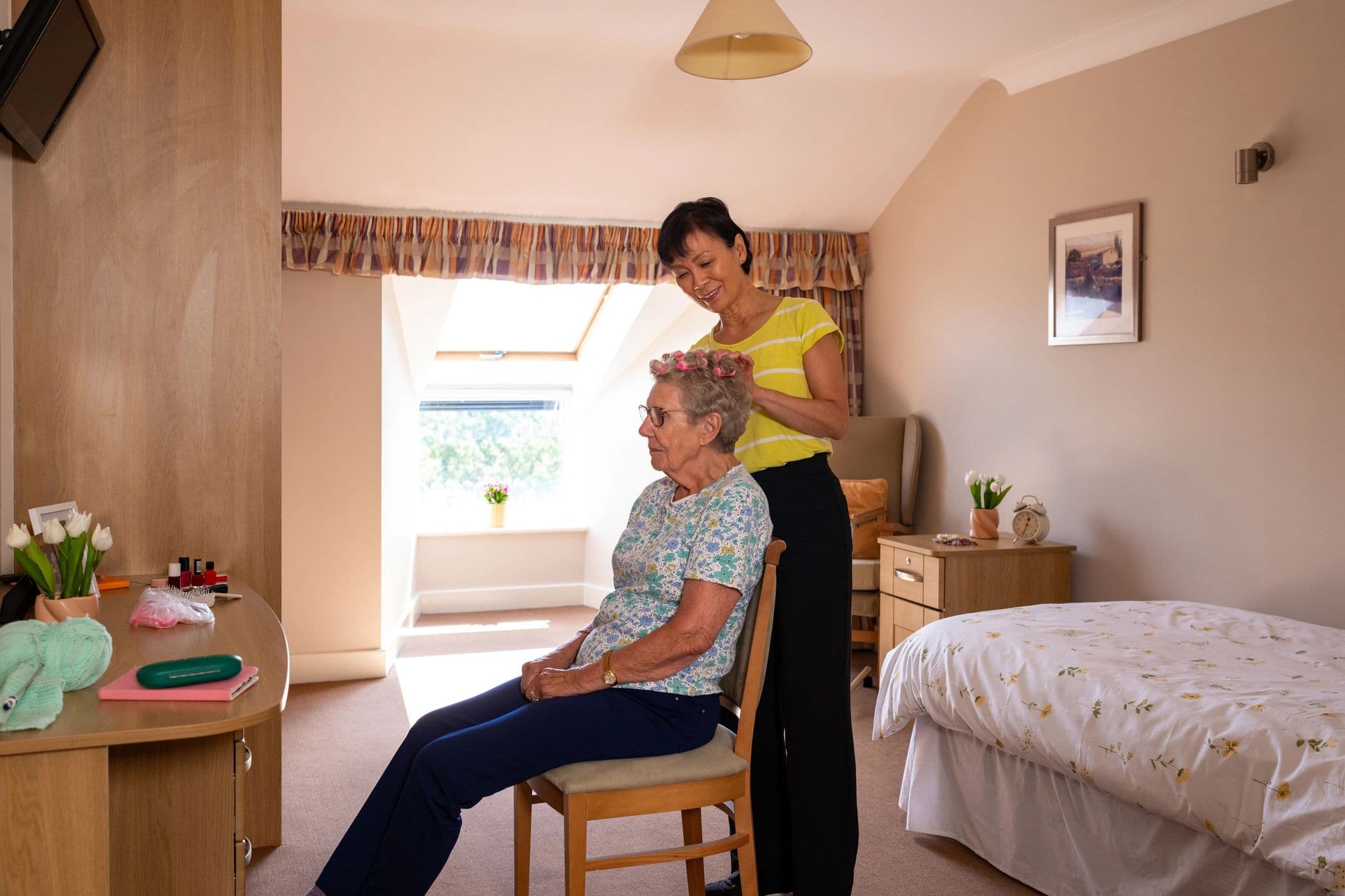 Caregiver helping an older woman with her hair