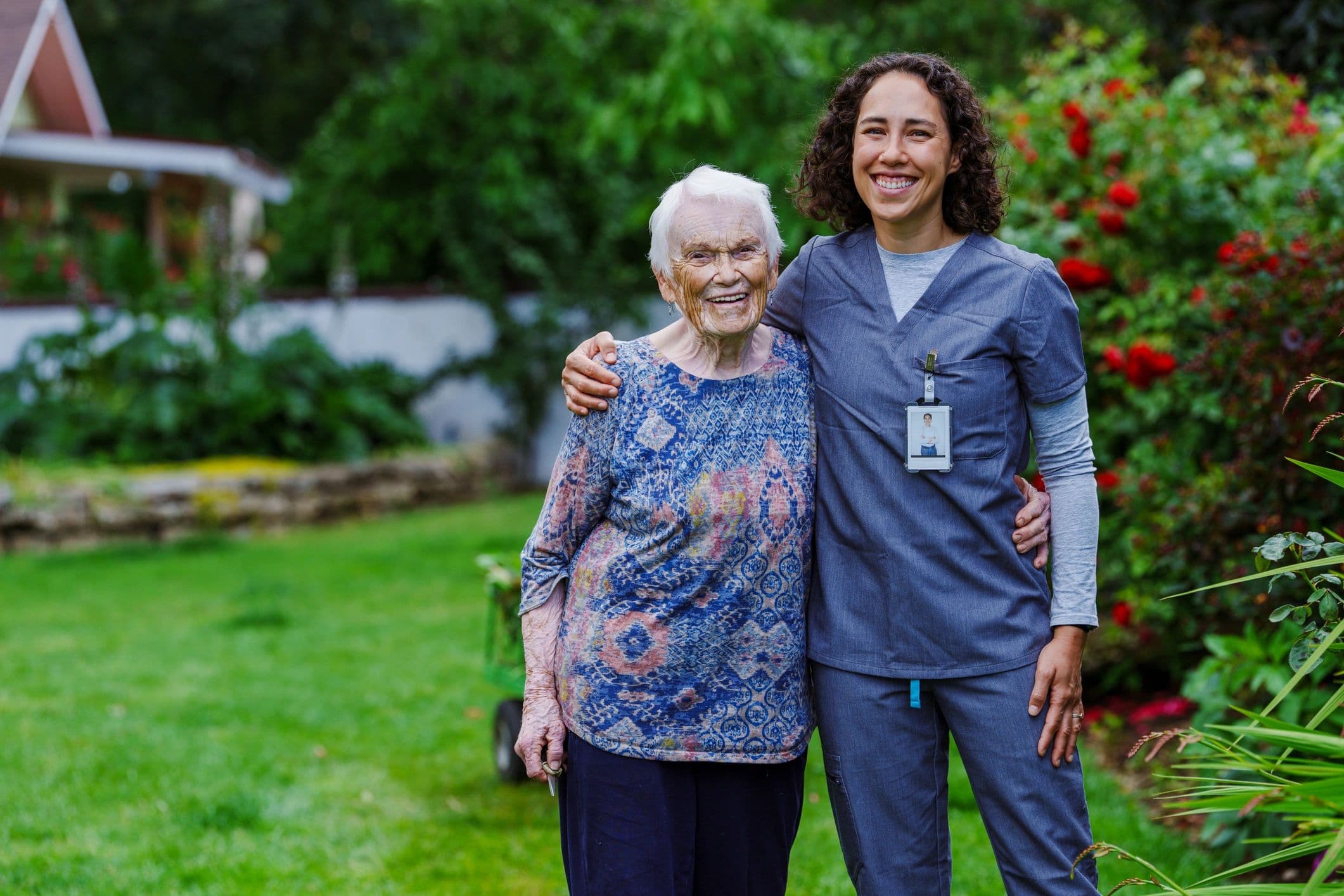 Nurse and older adult together in a garden